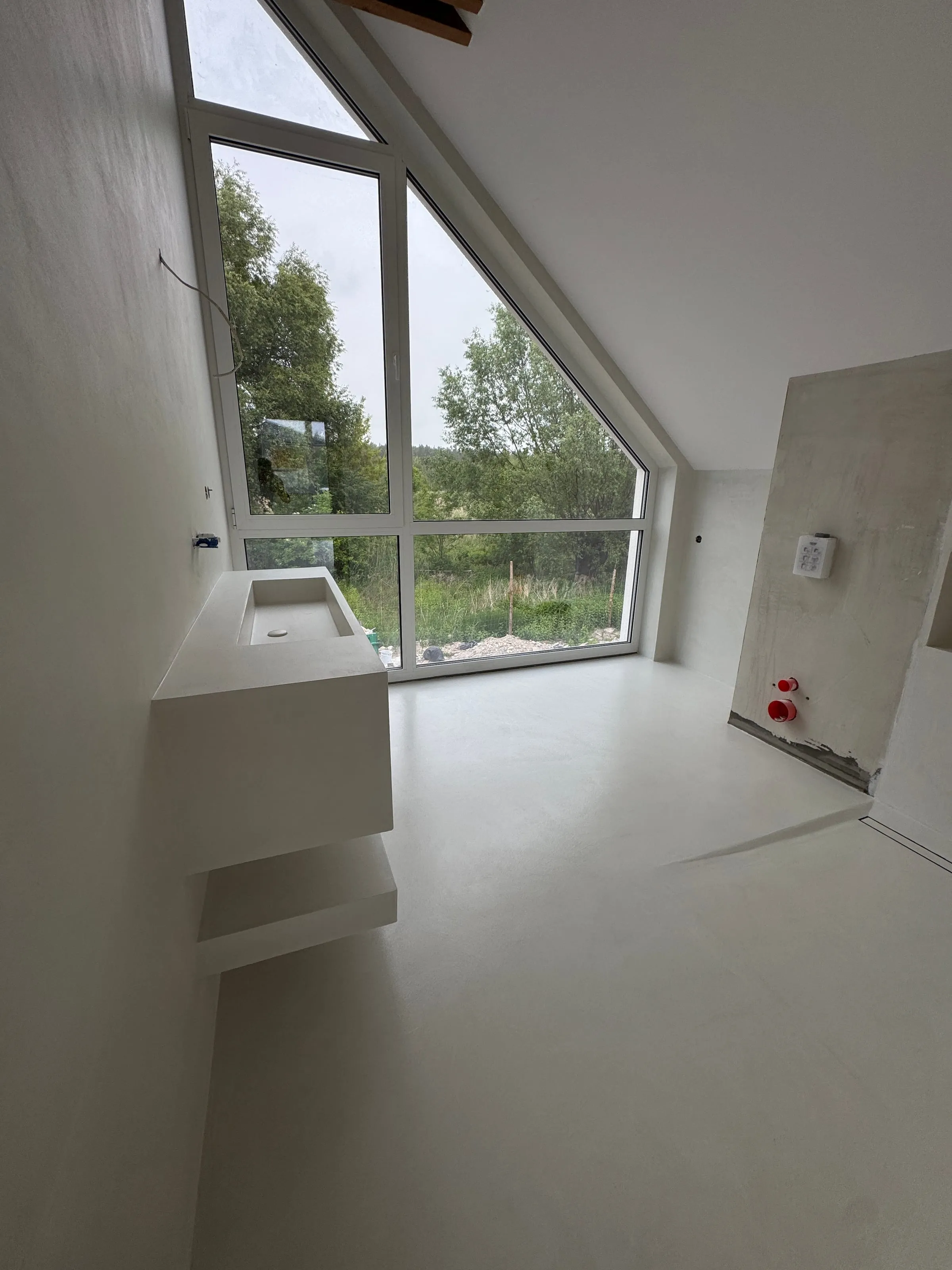 Rzeźbiarskie schody z mikrocementu z pełną balustradą