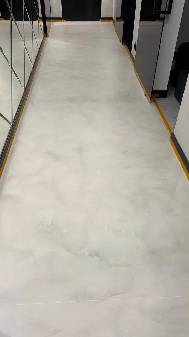 Strefa kuchni z wyspą i posadzką z mikrocementu