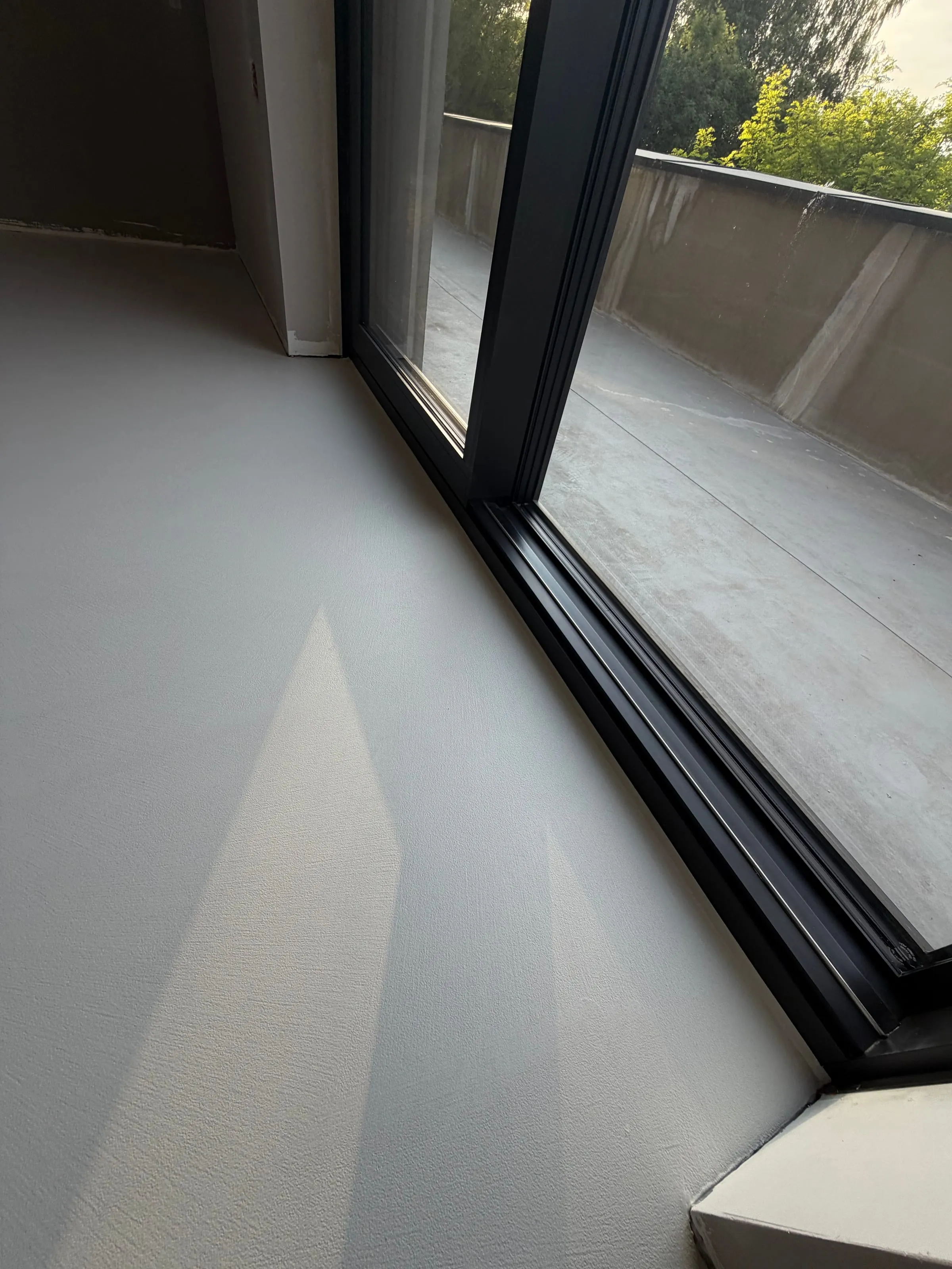 Wnętrze z posadzką z mikrocementu i wyjściem na taras